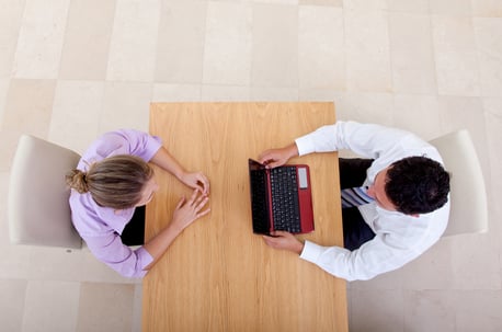 Business couple in an office working on a laptop