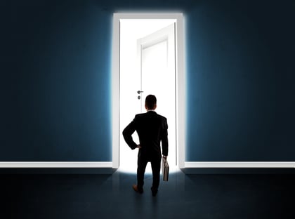 Business man looking at big bright opened door concept