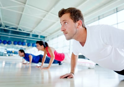 Group of people exercising at the gym doing push ups