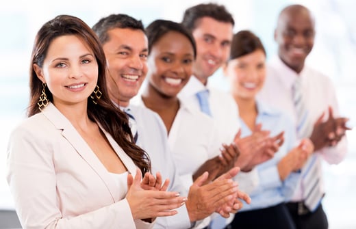 Successful business team applauding at the office looking happy