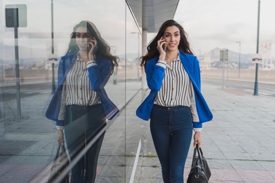 businesswoman-walking-while-talking-phone_23-2147604957